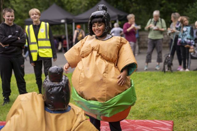 People watching 2 children sumo wrestle