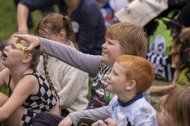 Children smiling, watching a performance