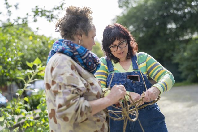 2 people creating willow weaving