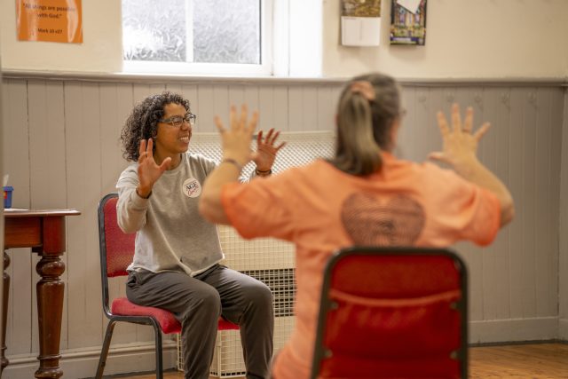 2 adults doing seated exercises