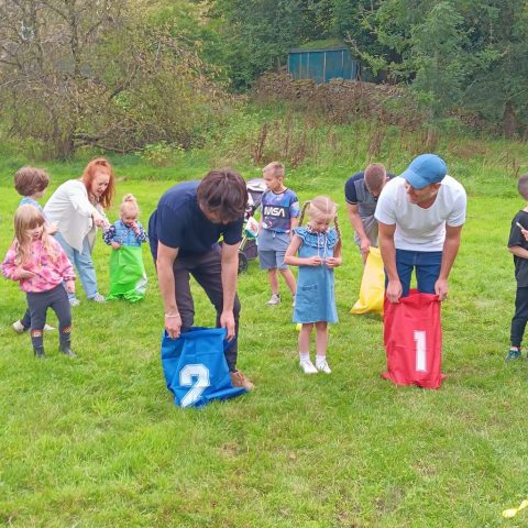 Adults taking part in sack race - sports day games